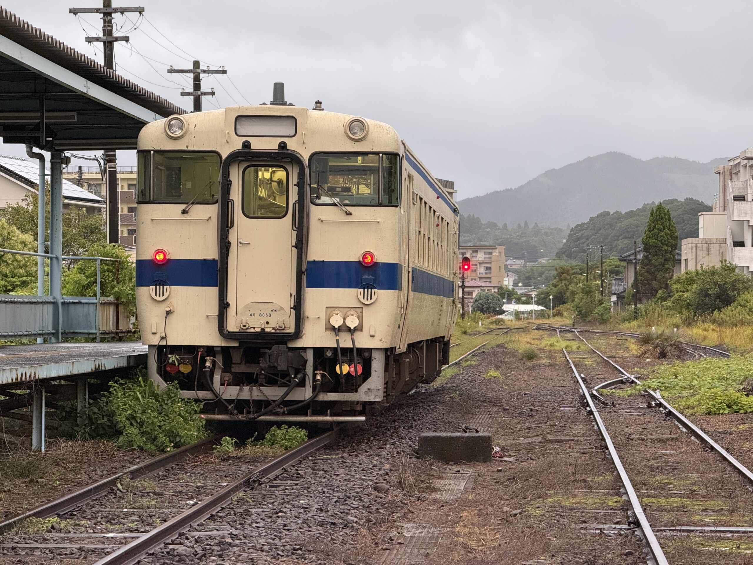 志布志駅 キハ40 8069 25.4℃ 風強め 小雨 草絡み 人影なし