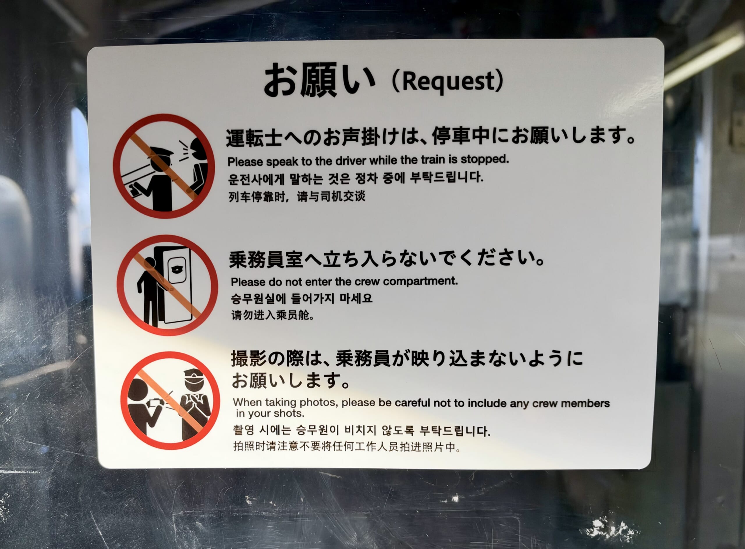 運転席後ろの窓に貼られた多言語注意シール